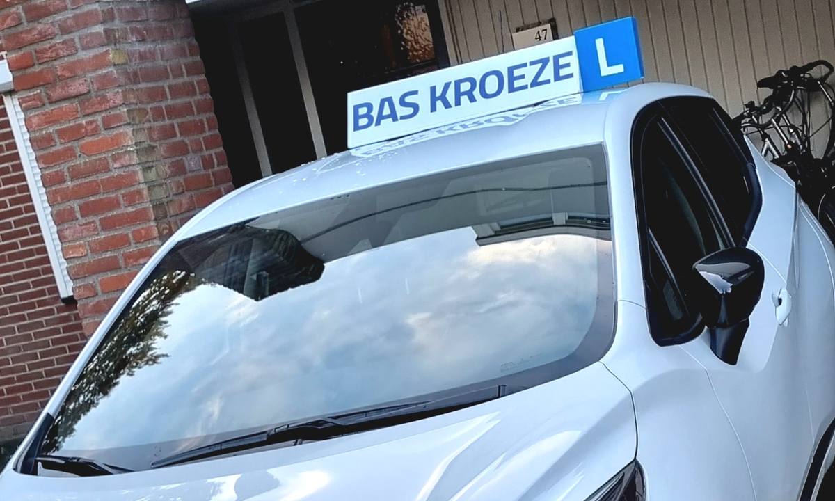 De lesauto van Autorijschool Bas Kroeze met het dakbord BAS KROEZE voor de woning aan de Leukerhof in Weert